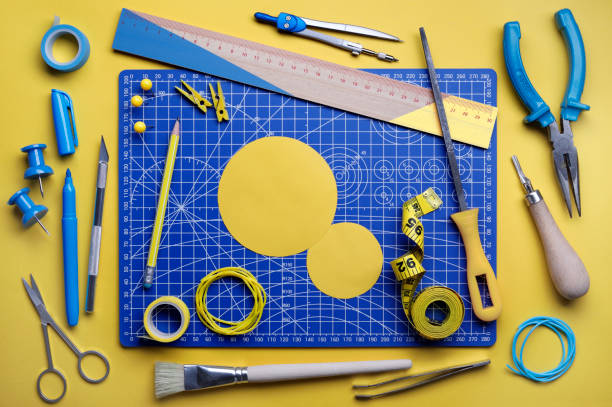 DIY Supplies Various yellow and blue DIY supplies on cutting mat. yellow scissors stock pictures, royalty-free photos & images