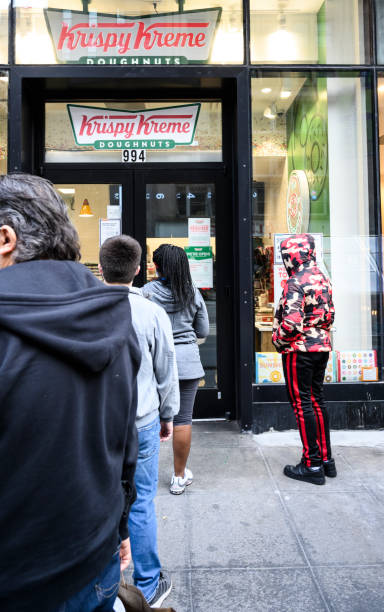 cola de la tienda krispy kreme - krispy kreme fotografías e imágenes de stock