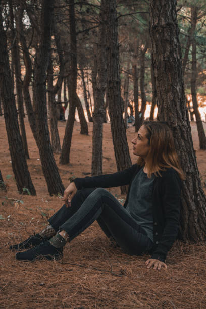 istock Woman is sitting and leaning tree in forest 1309623182