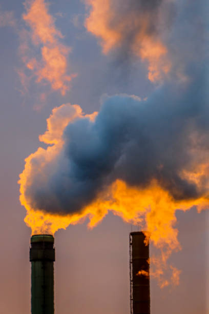 istock The sun goes down behind chimneys in a factory 1309623332