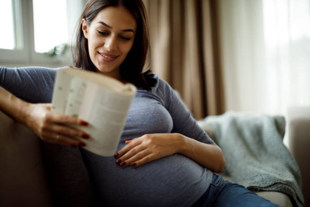 istock Pregnant woman reading a book 1309623339