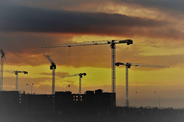 istock Construction, tower cranes are working on the background of the sunset. 1309624551