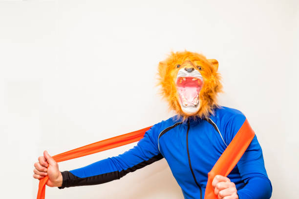 istock Man in a lion mask playing sport with an elastic band 1309624564