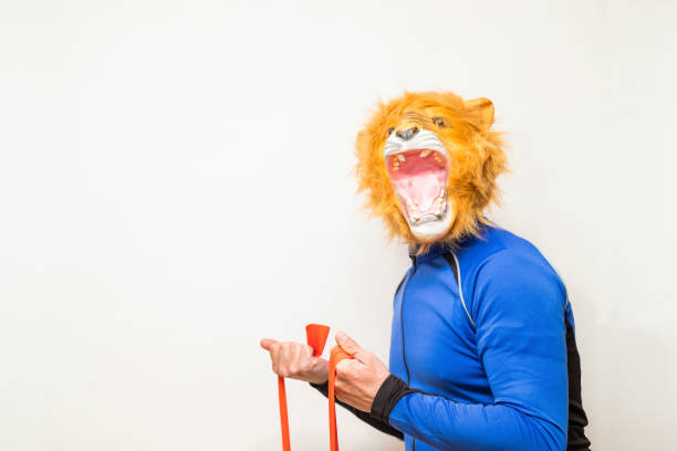 istock Man in a lion mask playing sport with an elastic band 1309624568