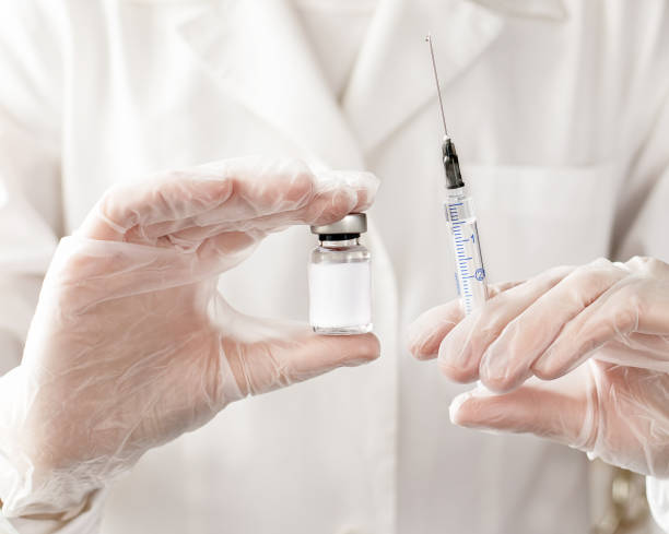istock Doctor's hand holding syringe and bottle for vaccine. Development and creation vaccines. Vaccination against influenza, viruses, infections. Selective focus. 1309625642