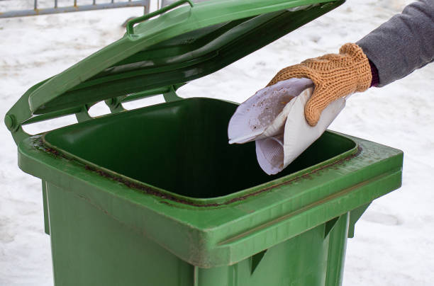 istock A female hand throws paper trash into a plastic container. The concept of sorting garbage, waste, for further processing 1309626870