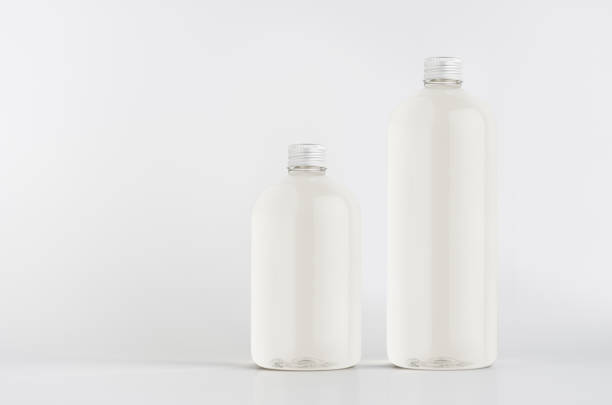 istock Set of two plastic tall and low bottles with water, silver cap mockup on white background, template, copy space. 1309627745