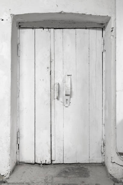 istock Old white wooden door in concrete wall 1309627763