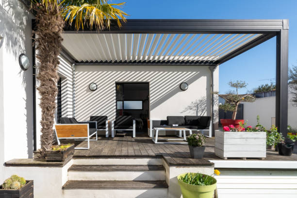 Trendy outdoor patio pergola. garden lounge, chairs, metal grill surrounded by landscaping Trendy outdoor patio pergola shade structure, awning and patio roof, garden lounge, chairs, metal grill surrounded by landscaping porch photos stock pictures, royalty-free photos & images