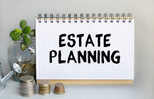 istock ESTATE PLANNING is written in a notebook that sits on the table along with a stack of coins, a glass jar with coins and a sprout, and a small toy watering can. Money saving concept. 1309632401