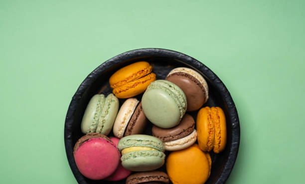istock Macaroon colorful desserts on green background top view 1309632719