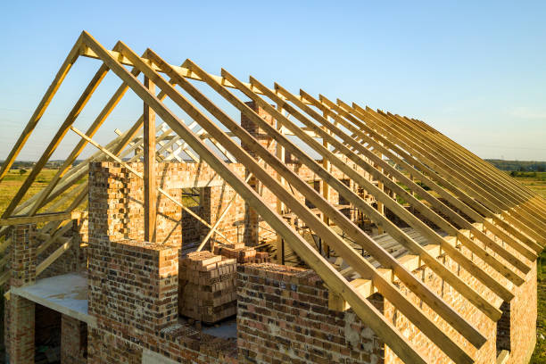 istock Unfinished brick house with wooden roof structure under construction. 1309634584