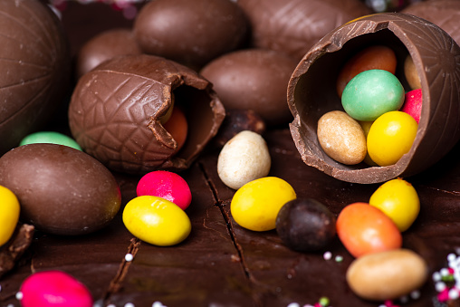 Chocolate Easter eggs and candies on top of a chocolate cake dessert closeup