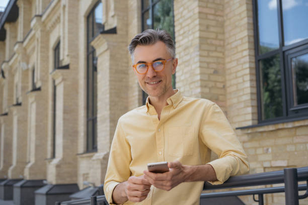 istock Mature man using smartphone standing on the street 1309639645