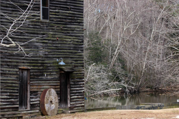 istock Mill Stone Rests Against Grist Mill Building 1309642879