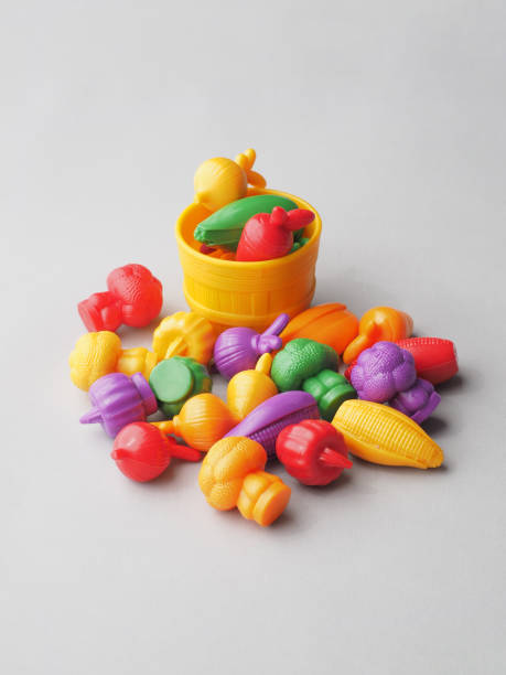 istock Many Colorful Plastic Vegetables in Wicker Basket on Gray. 1309646725