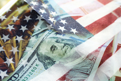 Benjamin Franklin en un billete de cien dólares con bandera americana y barra de oro de alta calidad photo