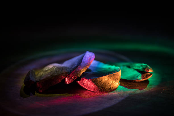 Parts of broken stone on a wooden table. Colorful lights on stones in selective focus. Close up