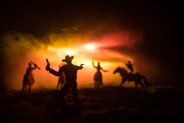 istock Western cowboy silhouette with texture at sunset and slivers of light 1309659705