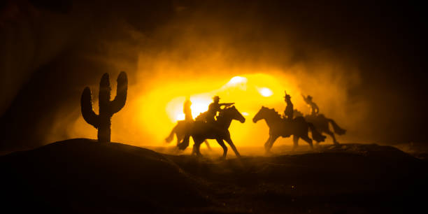 istock Western cowboy silhouette with texture at sunset and slivers of light 1309659709