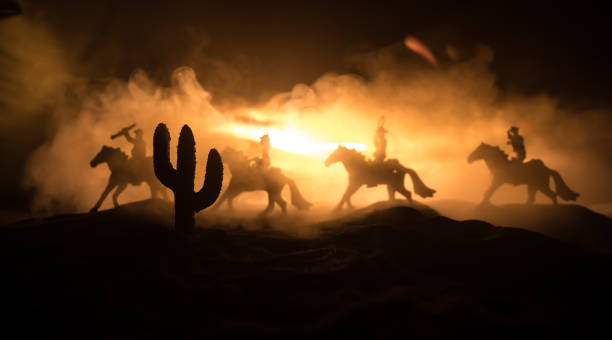 istock Western cowboy silhouette with texture at sunset and slivers of light 1309659715