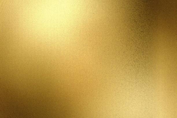 istock Light shining on gold painted metallic wall with copy space, abstract texture background 1309661961