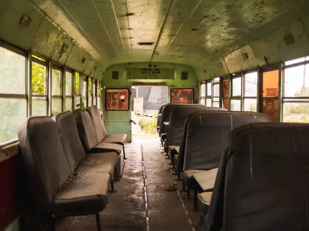 interior of an abandoned school bus with broken seats