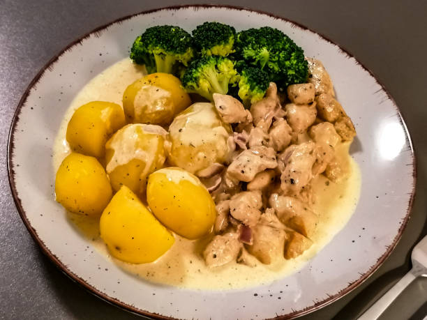 istock Boiled potatoes with broccoli and fried meat with cream sauce 1309667522
