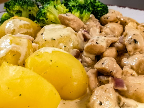 istock Boiled potatoes with broccoli and fried meat with cream sauce 1309667532