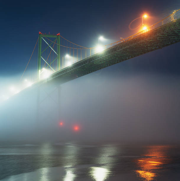 passerelle sur la nuit brumeuse - halifax nova scotia vertical traffic photos et images de collection