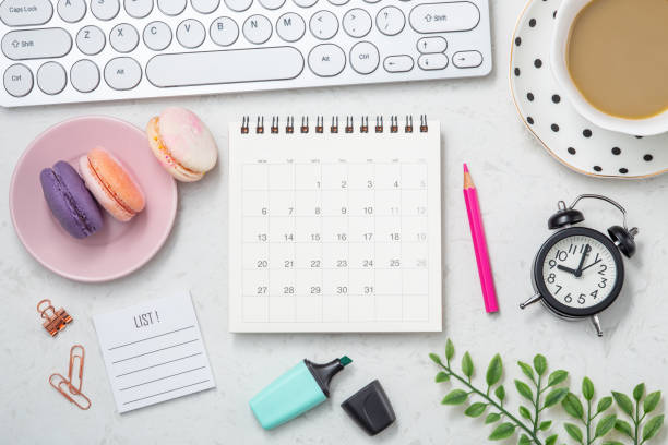 istock Calendar with clock, coffee cup and candy on office table 1309668602