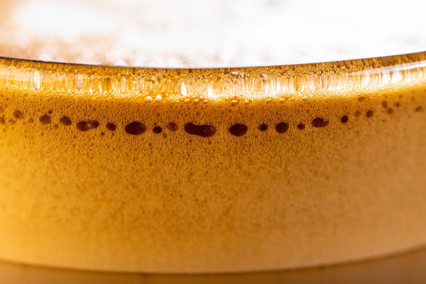 A very close view of frothy bubbles in a clear glass