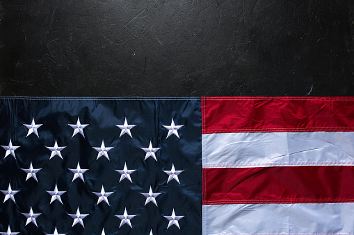 USA flag on dark concrete background.\nEmpty space provided for text placement for US celebrations such as: Memorial Day, Independence Day, etc.