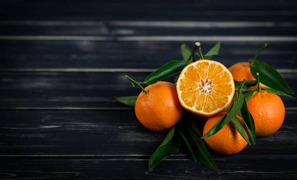 istock Mandarins with leaves on the black background 1309682066