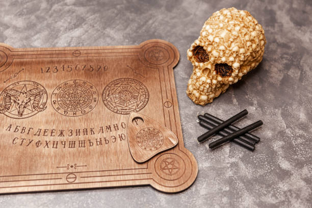 istock People conducting a seance using a talking spirit board. Ouija board 1309682079