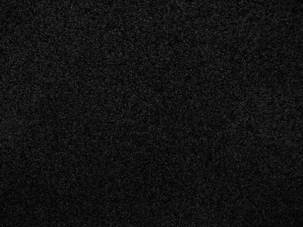 istock Black abstract background. Concrete wall finished with marble chips. Black stone background with copy space for design. 1309684319