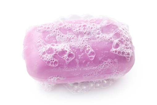 Bar of soap with soap bubbles isolated on white background.