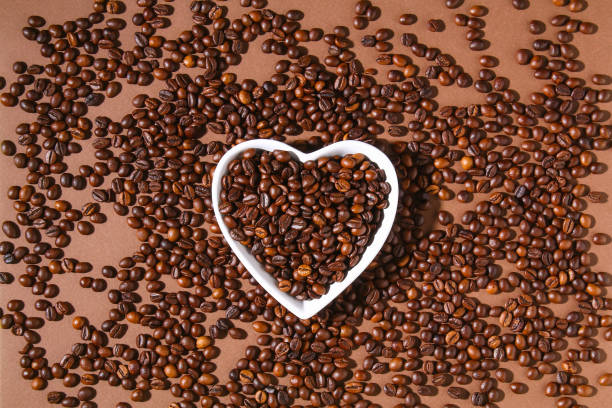 istock Roasted brown coffee beans on a brown background. 1309685307