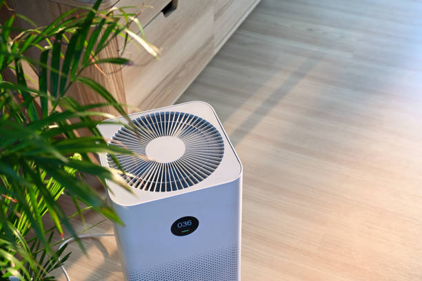 Air purifier on wooden floor in comfortable home. Fresh air and healthy life. stock photo