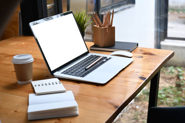 istock Comfortable workplace with computer laptop, notebook, coffee cup and pencil holder on wooden table. 1309686027