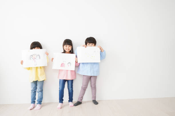 istock Little children showing their drawings 1309688415