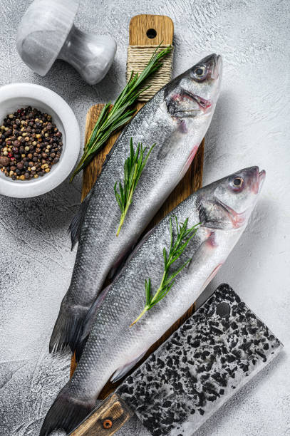 istock Raw Fresh fish seabass and ingredients for cooking. White background. Top view 1309693435