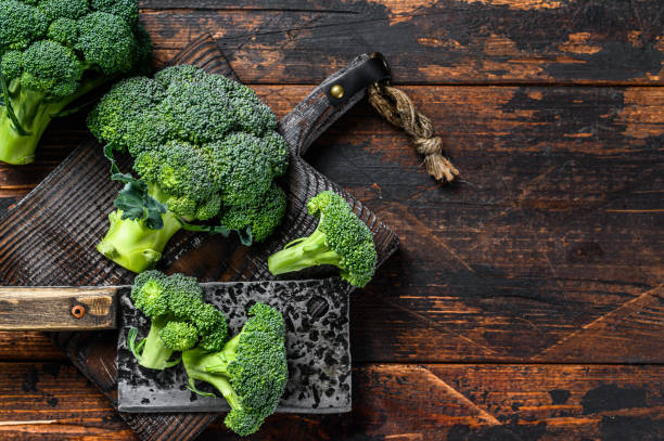 istock Raw Cut broccoli on a cutting board. Dark wooden background. Top view. Copy space 1309693456