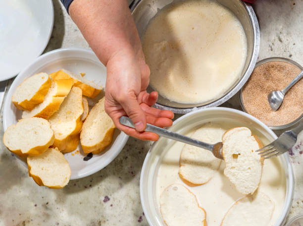 top view of a woman preparing torrijas (french toast) a typical spanish dish for holy week. - french toast breakfast food sweet food imagens e fotografias de stock