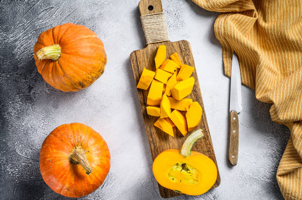istock Raw pumpkin cubes on a cutting Board. White background. Top view 1309697975