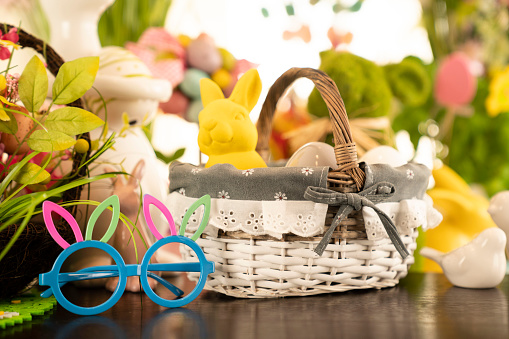 Easter bunny, easter eggs in basket and cabbage leaf. Bouquets of spring flowers.