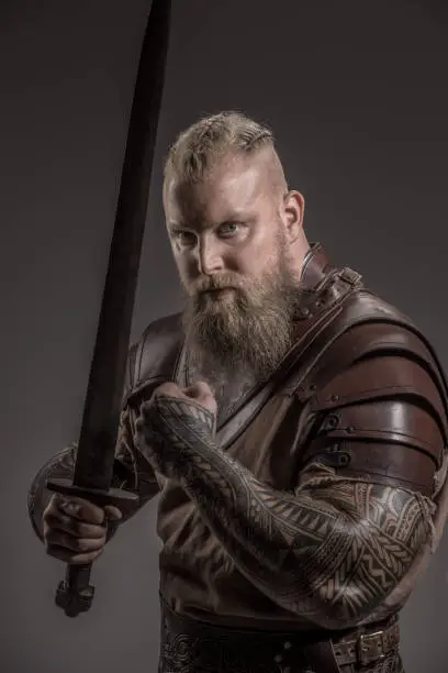 Weapon wielding redhead viking warrior in studio shot