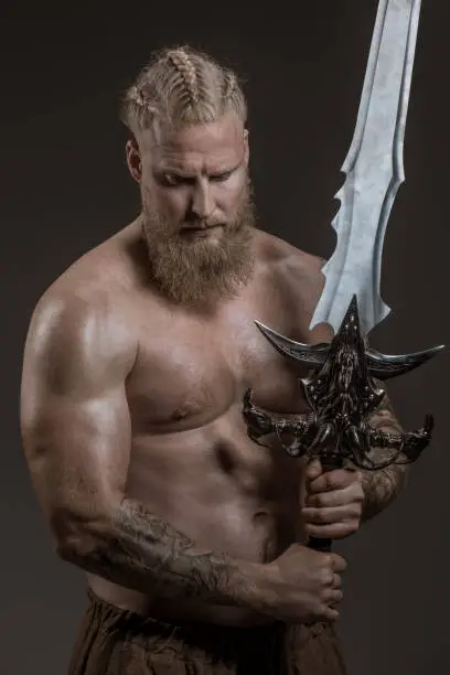 Weapon wielding redhead viking warrior in studio shot