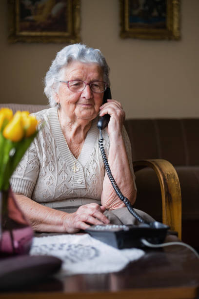 istock Lovely elderly lady having phone conversation 1309701225