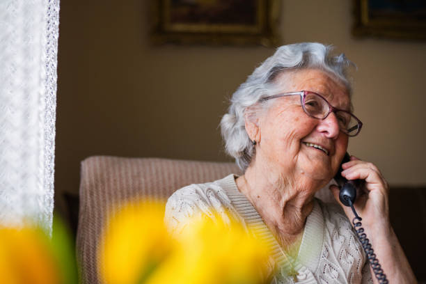 istock Elderly woman having phone conversation and smiling 1309701230